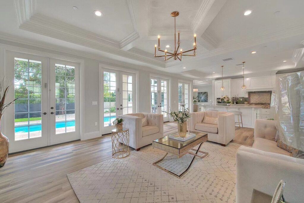 white and beige themed residential living room with a coffee table and large windows