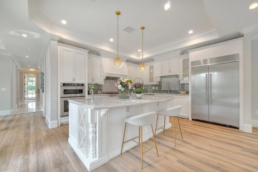white marble kitchen with two stools and hanging lights